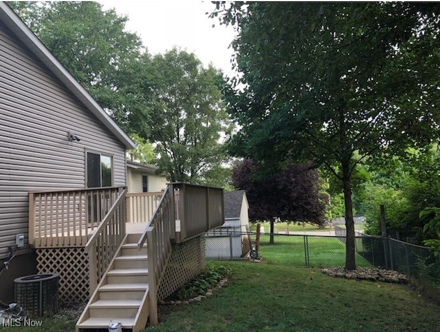 view of yard with central air condition unit and a wooden deck