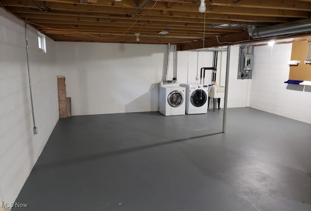 basement featuring washing machine and clothes dryer and sink