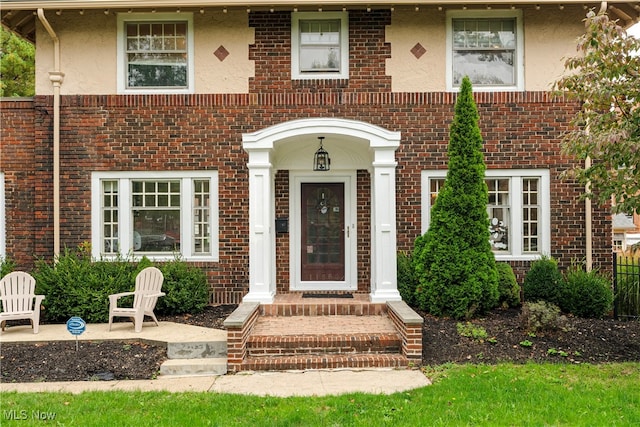 doorway to property with brick siding