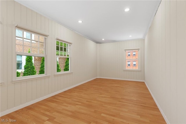 empty room featuring recessed lighting, light wood-style floors, and crown molding