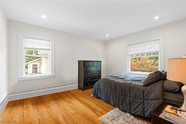 bedroom with multiple windows, recessed lighting, and light wood finished floors