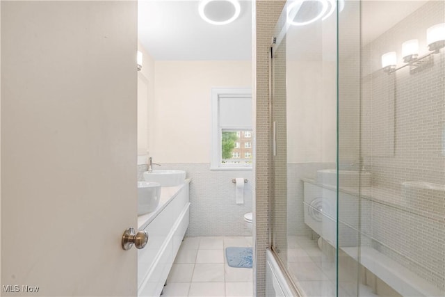 bathroom featuring vanity, a stall shower, wainscoting, tile walls, and tile patterned floors