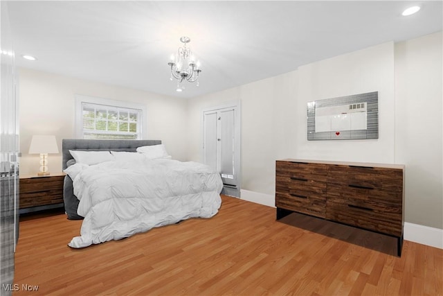 bedroom featuring recessed lighting, wood finished floors, baseboards, and a chandelier