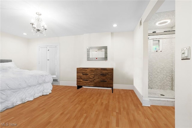 bedroom featuring light wood finished floors, a notable chandelier, and baseboards