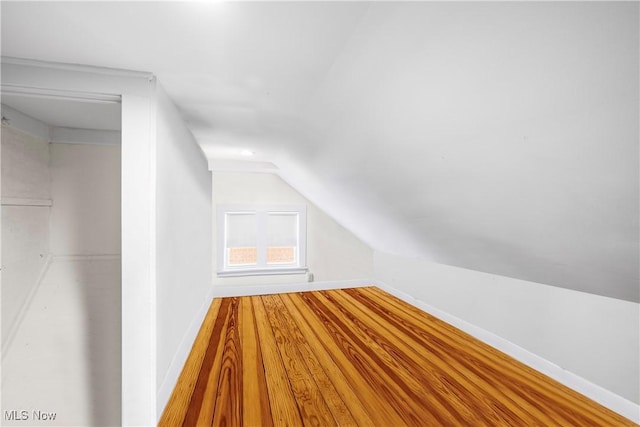 bonus room featuring vaulted ceiling, wood finished floors, and baseboards