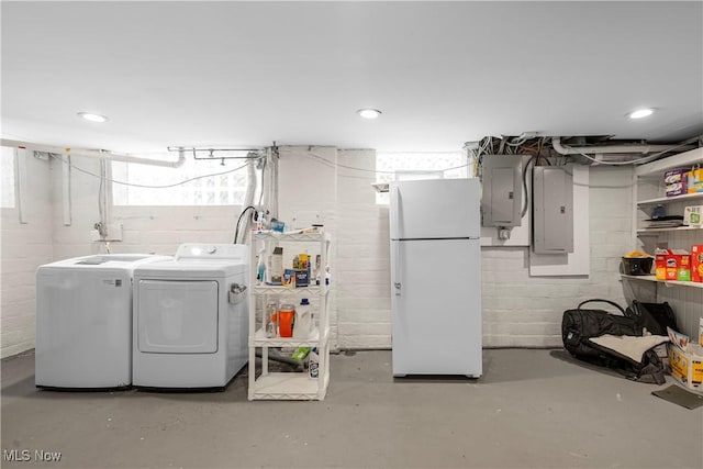 below grade area featuring washer and dryer, electric panel, recessed lighting, and freestanding refrigerator