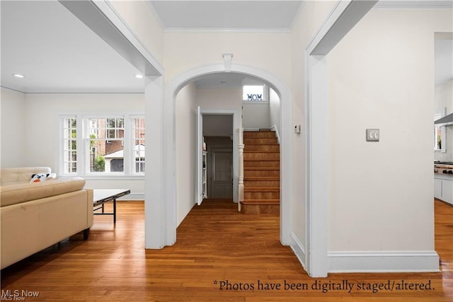 hallway with crown molding, stairs, recessed lighting, arched walkways, and wood finished floors