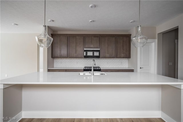 kitchen with pendant lighting and a center island with sink