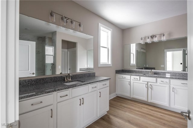 bathroom featuring vanity, wood-type flooring, and walk in shower