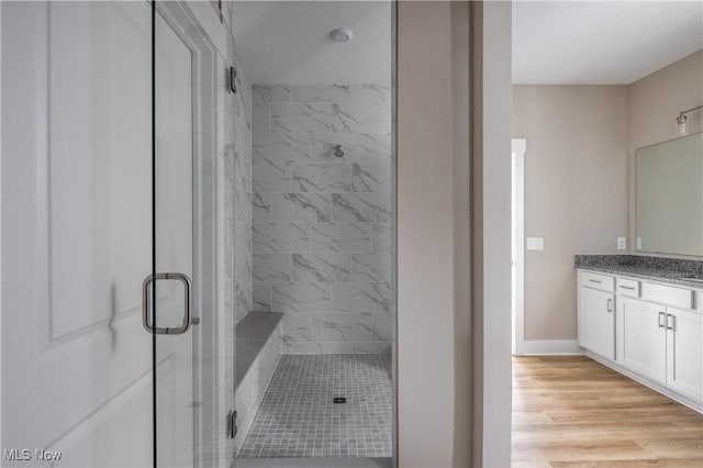 bathroom with vanity, a shower with shower door, and wood-type flooring