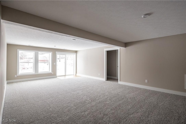 carpeted empty room with a textured ceiling