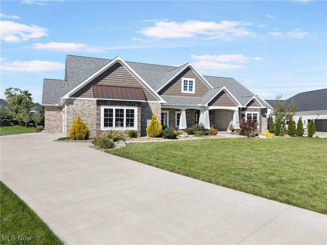 view of front of house featuring a shingled roof, metal roof, a standing seam roof, a front lawn, and brick siding