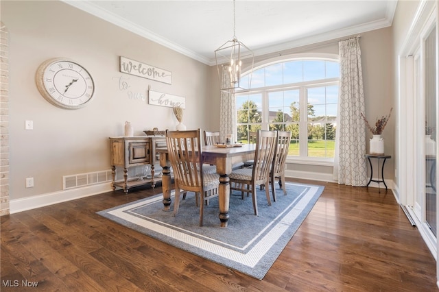 dining area with an inviting chandelier, crown molding, and dark hardwood / wood-style flooring