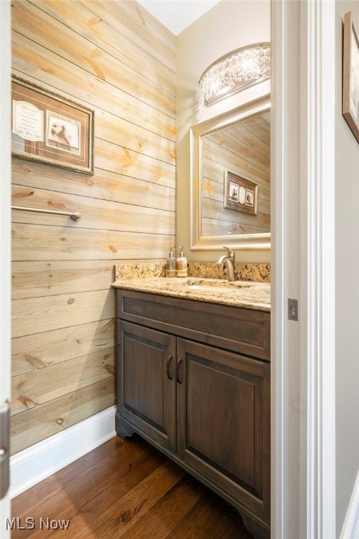 bathroom featuring wooden walls, vanity, and hardwood / wood-style flooring