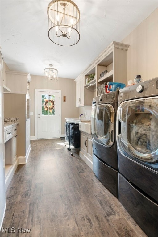 washroom with an inviting chandelier, dark hardwood / wood-style floors, and washer and dryer