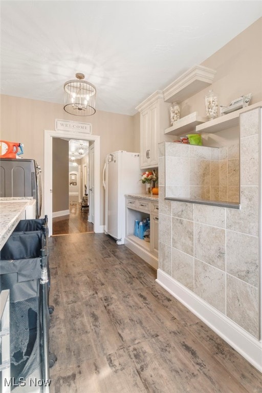 kitchen with a notable chandelier, washer / dryer, dark hardwood / wood-style floors, and white fridge