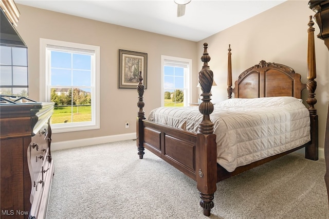 bedroom with ceiling fan, light carpet, and multiple windows