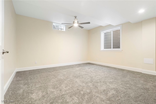 carpeted spare room featuring a ceiling fan and baseboards