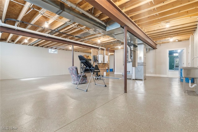 basement with water heater and a sink