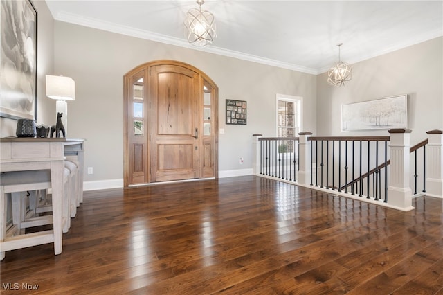 foyer with an inviting chandelier, crown molding, dark hardwood / wood-style flooring, and a healthy amount of sunlight