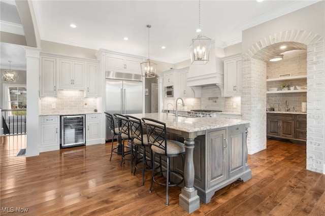 kitchen featuring beverage cooler, appliances with stainless steel finishes, dark hardwood / wood-style flooring, and white cabinetry