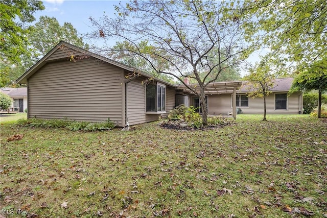 rear view of property featuring a lawn