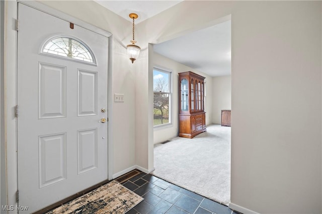 entrance foyer featuring dark colored carpet