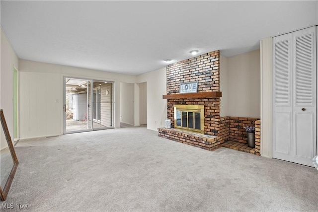 unfurnished living room featuring a brick fireplace and carpet flooring