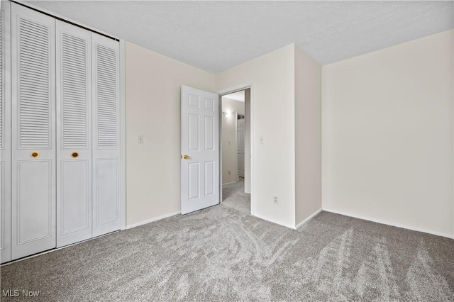 unfurnished bedroom with light colored carpet, a textured ceiling, and a closet