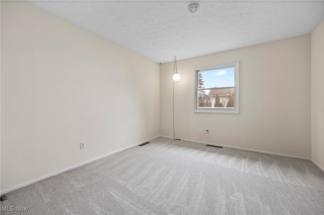 spare room with a textured ceiling and carpet