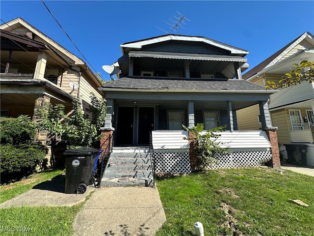 view of front of house with covered porch and a front lawn