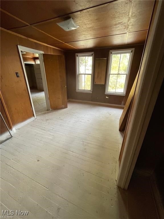 interior space featuring wooden walls, light hardwood / wood-style flooring, and wooden ceiling