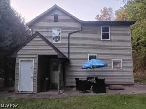 back of house featuring a lawn and a patio