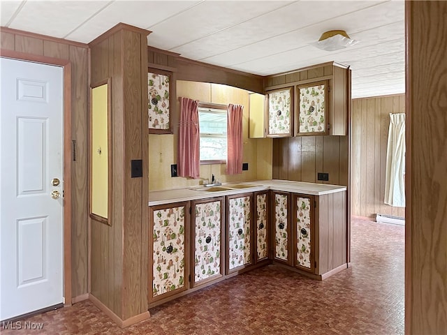 kitchen with wood walls, sink, and a baseboard heating unit