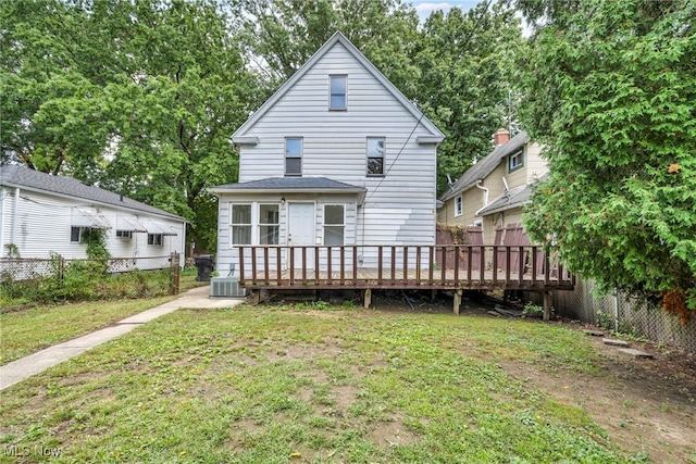 rear view of property with central AC unit, a yard, and a wooden deck