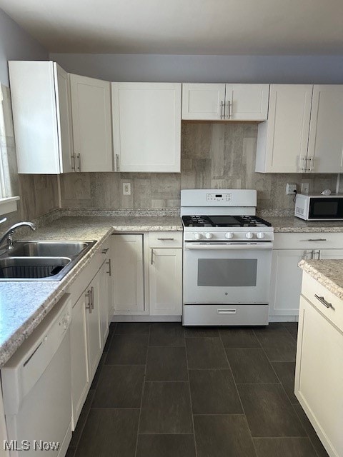 kitchen with white cabinets, sink, white appliances, and tasteful backsplash