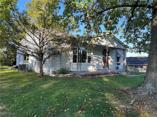 view of front of house with cooling unit and a front lawn