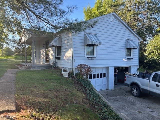 view of side of home with a yard and a garage