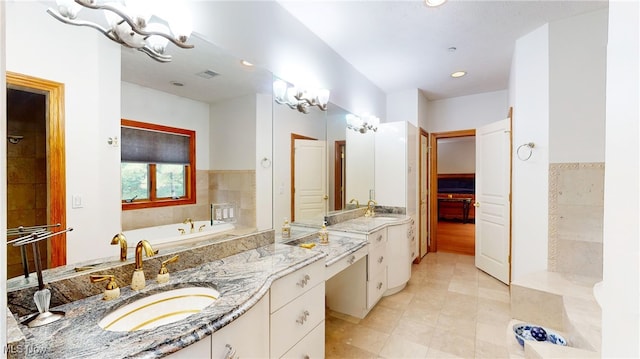 bathroom with a bathing tub, tile patterned flooring, and vanity