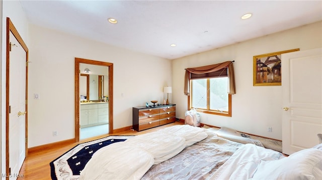 bedroom featuring light wood-type flooring and ensuite bathroom