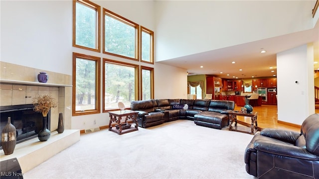 living room with a towering ceiling and light colored carpet