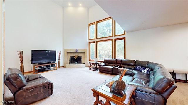 carpeted living room with high vaulted ceiling, a tiled fireplace, and plenty of natural light