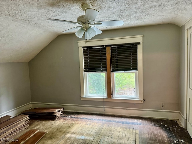 additional living space featuring a textured ceiling, lofted ceiling, ceiling fan, and hardwood / wood-style flooring