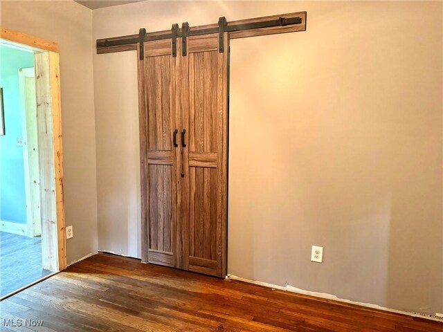 interior space with dark hardwood / wood-style floors and a barn door