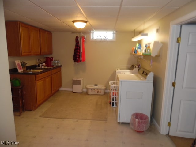 clothes washing area with washer / clothes dryer and sink