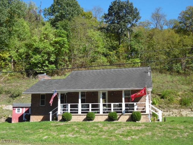 view of front of property featuring covered porch and a front yard