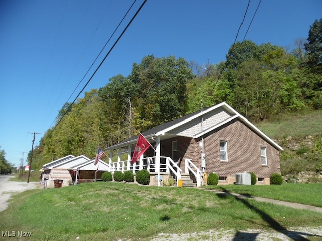 view of front facade featuring central AC unit and a front lawn