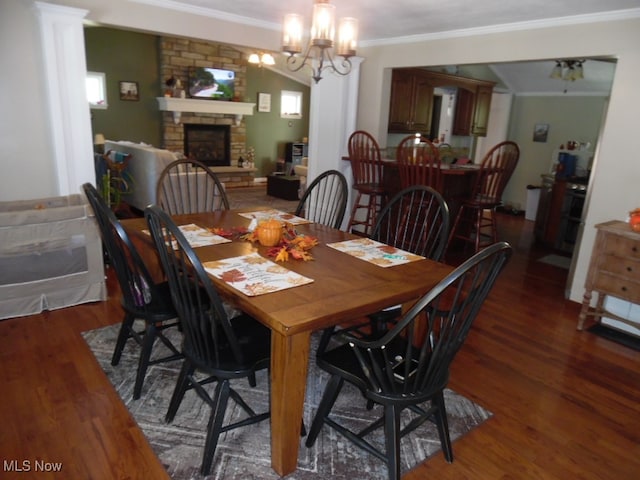 dining room with an inviting chandelier, a fireplace, dark hardwood / wood-style floors, and crown molding