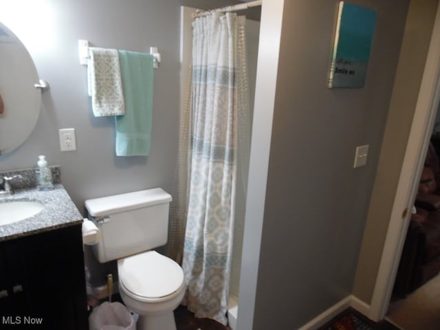 bathroom with curtained shower, vanity, and toilet