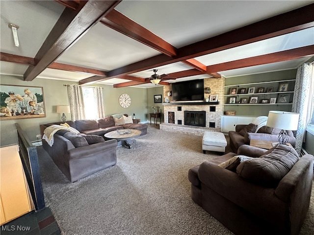 living room with a fireplace, beamed ceiling, carpet flooring, ceiling fan, and built in shelves